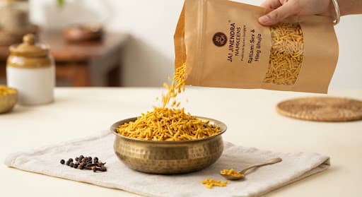 Ratlami Sev and Hing Bhujia poured into a brass bowl